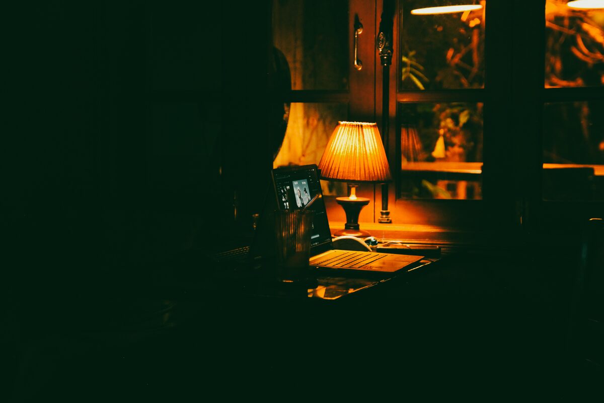Biurko oświetlone lampką w ciemnym pomieszczeniu nocą
